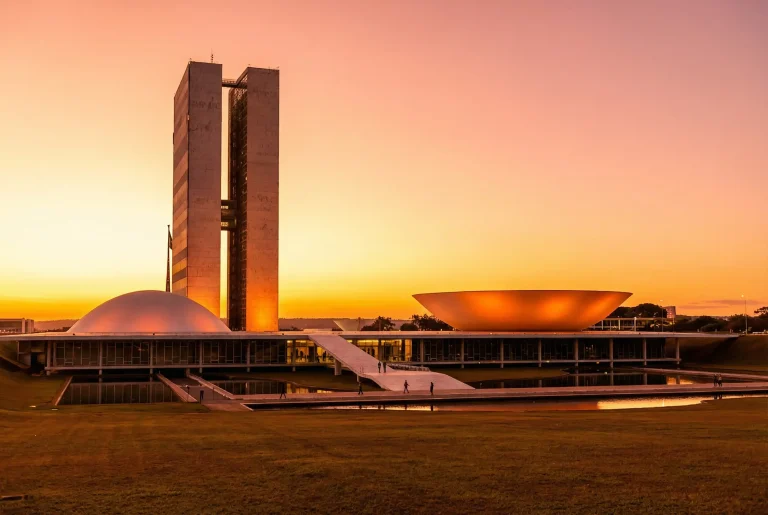 Congresso Nacional em Brasília ao entardecer com céu dourado